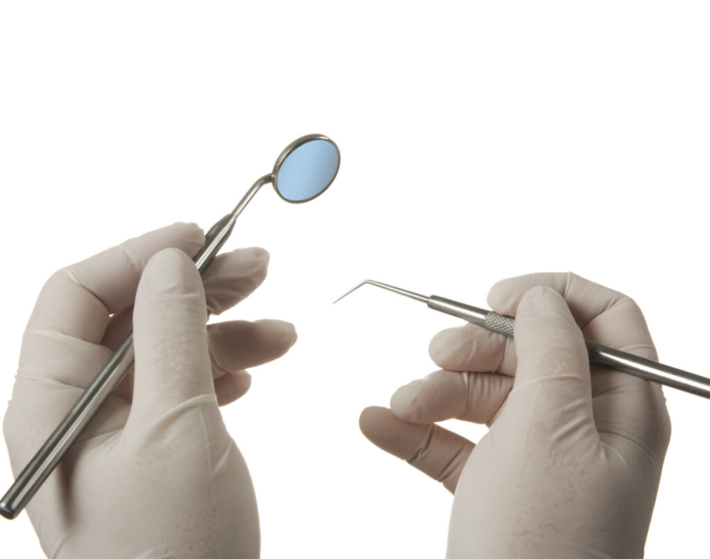 Miroir et sonde, mains gantées